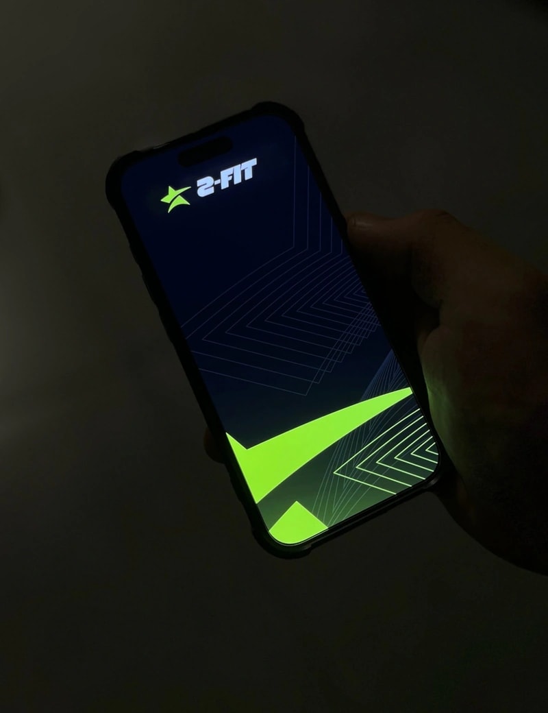 Telefon z aplikacją treningową w dłoni